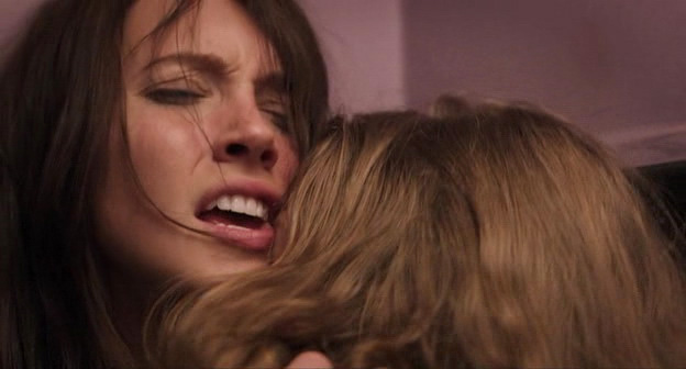 Katie Cassidy and Tracy Spiridakos making out passionately in a bathroom