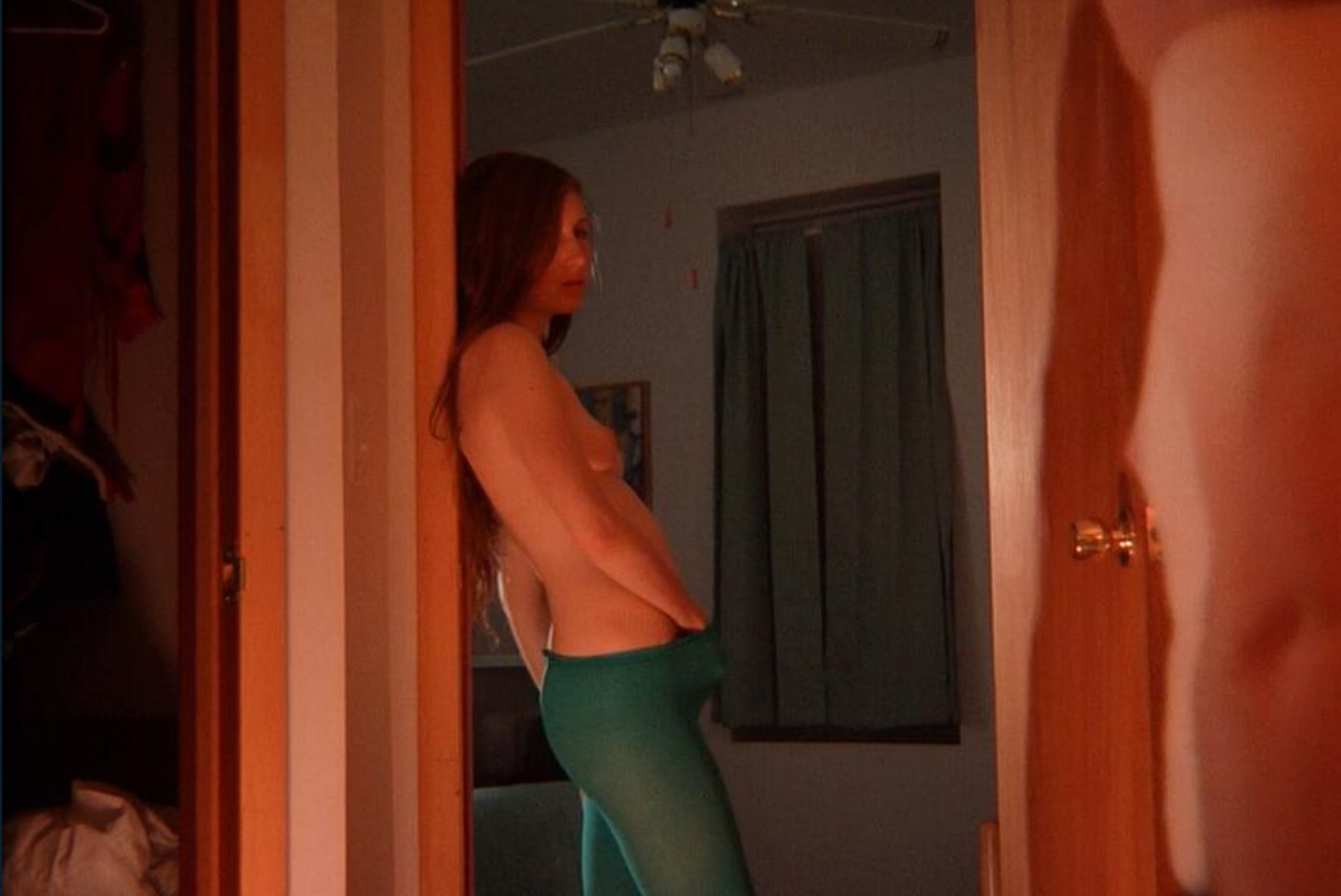 Kate Lyn Sheil puts a hand down under the sheet and masturbates